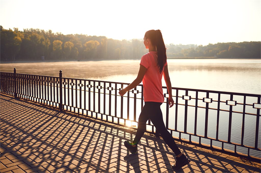 Ragazza che cammina su un lungolago al mattino